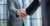 Two diverse professional business men executive leaders shaking hands at office meeting